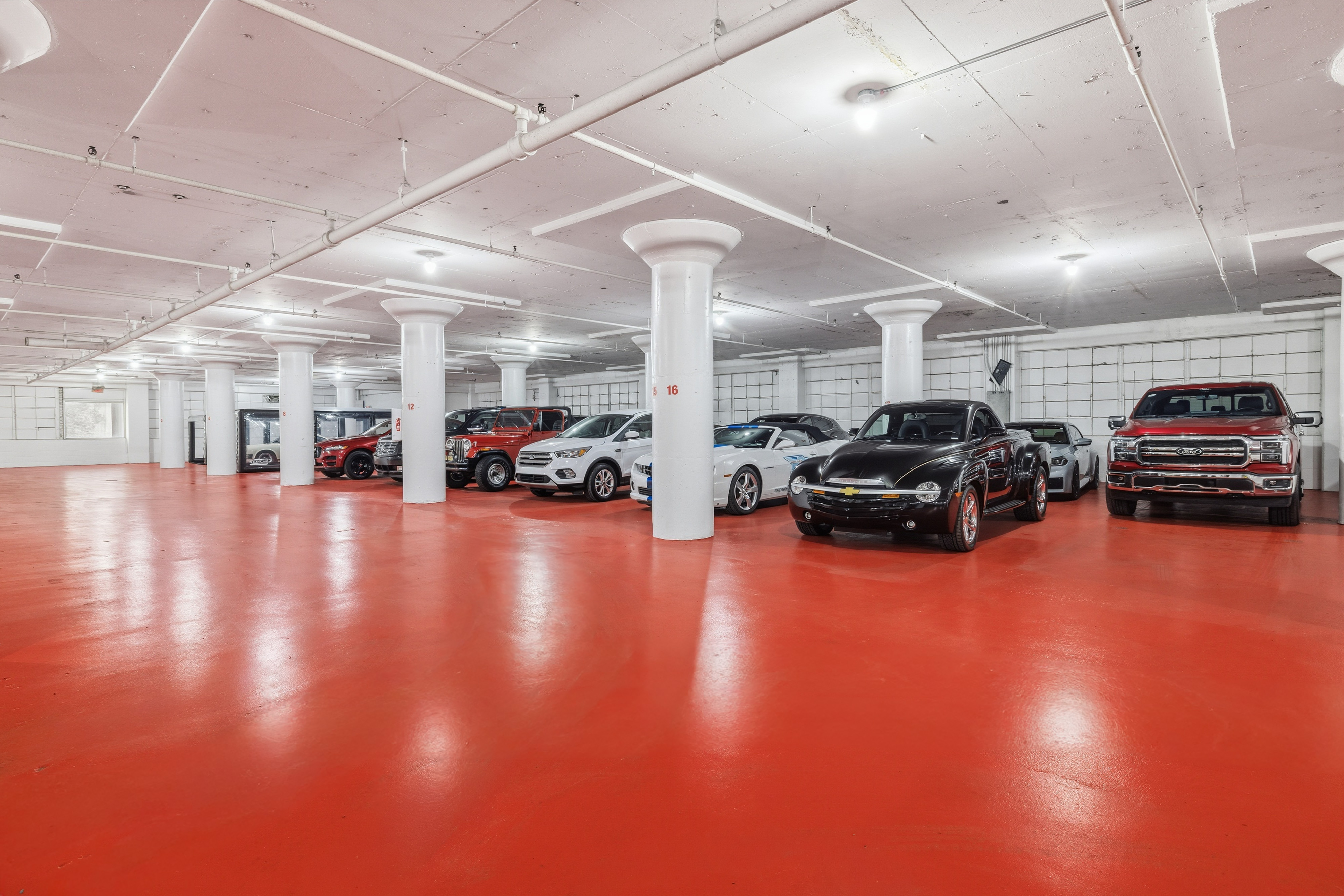 Indoor vehicle storage facility filled with cars on a red floor