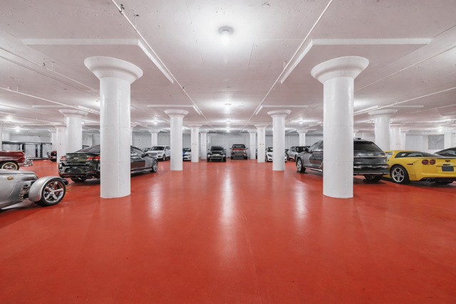 Wide view of our indoor parking facility with vehicles stored on a red floor